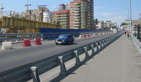 По левой части моста запустили одностороннее движение транспорта и пешеходную часть, правая половина моста в стадии строительства.